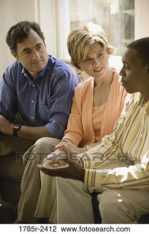 Stock Image - Mature couple talking with young man. Fotosearch