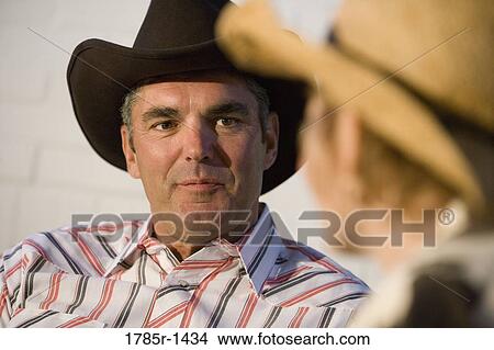 Mature couple wearing cowboy hats talking View Large Photo Image Picture - Mature couple wearing cowboy hats talking. Fotosearch