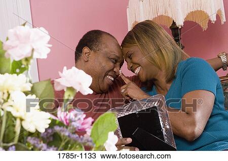 Stock Image - Mature romantic couple smiling at each other. Fotosearch