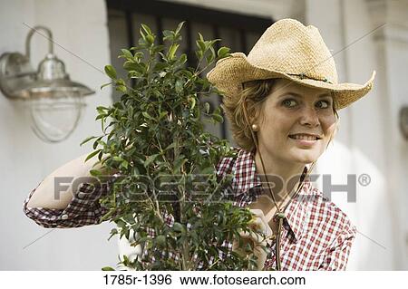 Mature woman tending plant View Large Photo Image Stock Photograph - Mature woman tending plant. Fotosearch