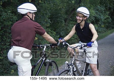 Mid adult couple riding bicycles View Large Photo Image Stock Photography - Mid adult couple riding bicycles. Fotosearch