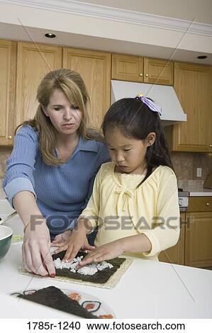 Mother and adopted daughter making sushi View Large Photo Image Stock Image - Mother and adopted daughter making sushi. Fotosearch