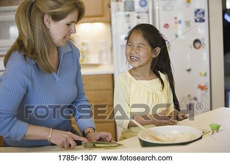 Mother and adopted daughter making sushi View Large Photo Image Stock Photo - Mother and adopted daughter making sushi. Fotosearch