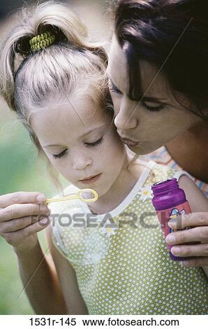 Stock Photography - Mother and daughter playing with a bubble wand. Fotosearch