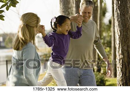 Mother and father playing with daughter in backyard View Large Photo Image Stock Photography - Mother and father playing with daughter in backyard. Fotosearch