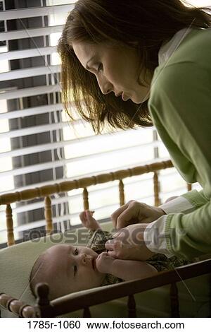 Stock Image - Mother with baby on diaper changing table. Fotosearch