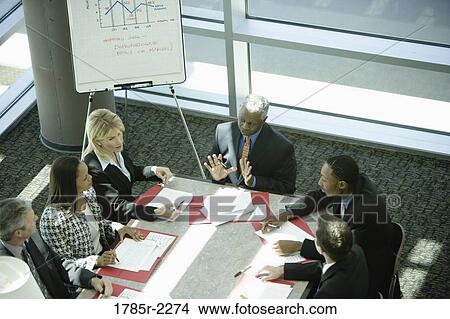 Picture - Overhead view of business colleagues in a meeting. Fotosearch
