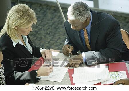 Stock Photo - Overhead view of business colleagues in a meeting. Fotosearch