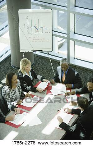 Overhead view of business colleagues in a meeting View Large Photo Image Stock Photograph - Overhead view of business colleagues in a meeting. Fotosearch