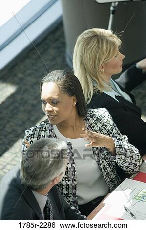 Overhead view of business colleagues in a meeting View Large Photo Image Stock Photograph - Overhead view of business colleagues in a meeting. Fotosearch