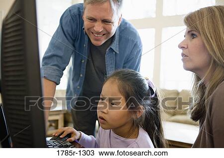 Parents and daughter looking at a computer View Large Photo Image Stock Image - Parents and daughter looking at a computer. Fotosearch