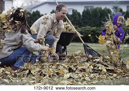 Stock Image - Parents and their daughter raking a lawn. Fotosearch