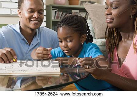 Parents reading and coloring with daughter View Large Photo Image Picture - Parents reading and coloring with daughter. Fotosearch