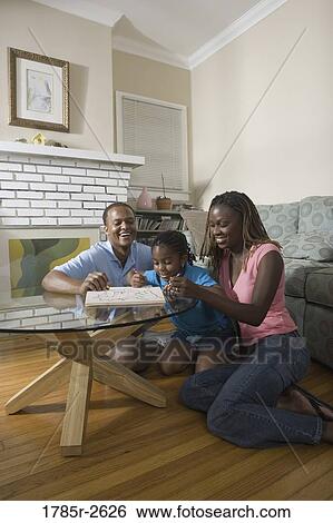 Parents reading and coloring with daughter View Large Photo Image Stock Photograph - Parents reading and coloring with daughter. Fotosearch