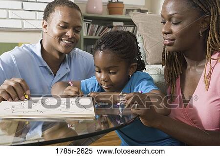 Parents reading and coloring with daughter View Large Photo Image Stock Photography - Parents reading and coloring with daughter. Fotosearch