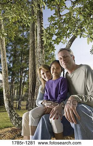 Parents sitting with daughter in backyard View Large Photo Image Stock Image - Parents sitting with daughter in backyard. Fotosearch