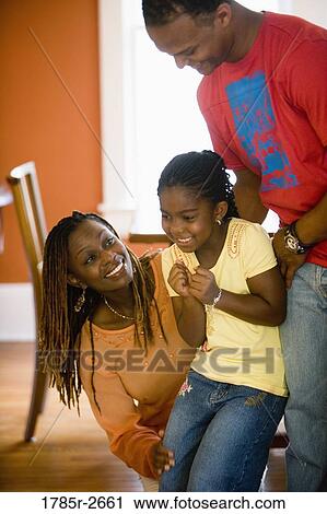 Parents with daughter playing inside house View Large Photo Image Stock Image - Parents with daughter playing inside house. Fotosearch