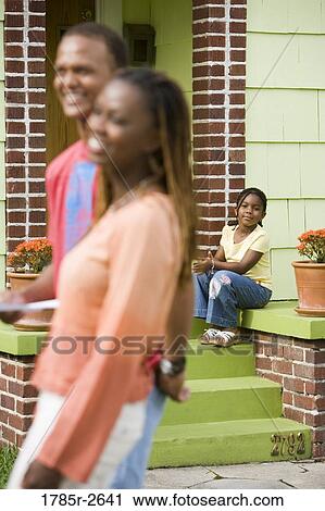 Parents with daughter sitting on steps outside house View Large Photo Image Stock Image - Parents with daughter sitting on steps outside house. Fotosearch
