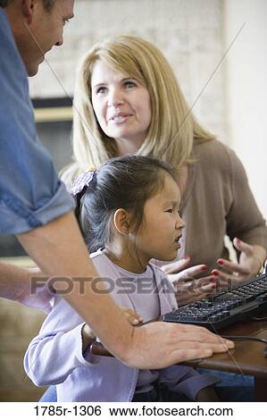 Parents with daughter working on a computer View Large Photo Image Stock Photograph - Parents with daughter working on a computer. Fotosearch