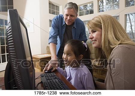 Parents with their daughter using computer View Large Photo Image Stock Photo - Parents with their daughter using computer. Fotosearch