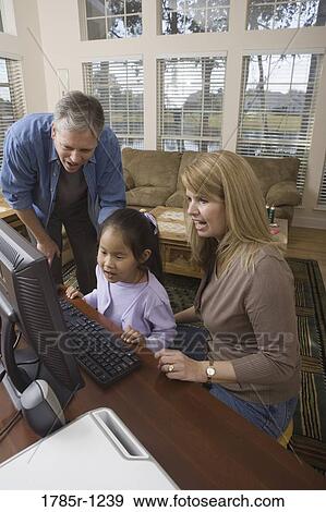Parents with their daughter using computer View Large Photo Image Stock Photo - Parents with their daughter using computer. Fotosearch