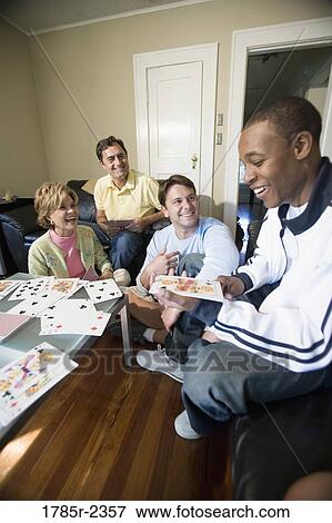 People playing cards in a living room View Large Photo Image Stock Photo - People playing cards in a living room. Fotosearch