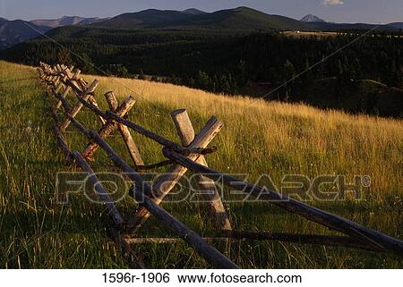 Stock Photograph - Pole fence in a field with pintlers in the background, Phillipsburg Valley, Montana, USA. Fotosearch