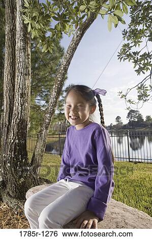 Portrait of a Asian girl smiling in backyard View Large Photo Image Stock Photograph - Portrait of a Asian girl smiling in backyard. Fotosearch