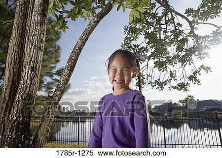 Portrait of a Asian girl smiling in backyard View Large Photo Image Stock Photography - Portrait of a Asian girl smiling in backyard. Fotosearch