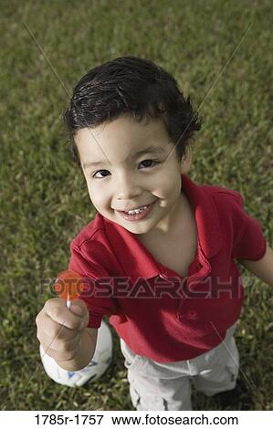 Stock Photo - Portrait of a boy holding lollipop. Fotosearch