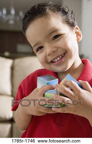 Portrait of a boy holding toys View Large Photo Image Stock Photograph - Portrait of a boy holding toys. Fotosearch