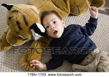 Portrait of a boy lying on a floor with stuffed animal View Large Photo Image Stock Image - Portrait of a boy lying on a floor with stuffed animal. Fotosearch