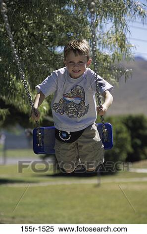 Stock Photography - Portrait of a boy playing on a swing. Fotosearch