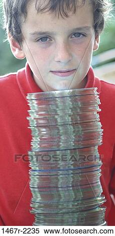 Portrait of a boy standing behind a stack of CD's View Large Photo Image Stock Photography - Portrait of a boy standing behind a stack of CD's. Fotosearch