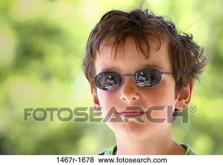 Stock Photo - Portrait of a boy wearing sunglasses. Fotosearch
