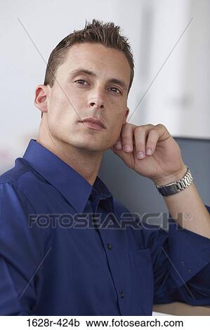 Portrait of a businessman sitting in an office View Large Photo Image Stock Image - Portrait of a businessman sitting in an office. Fotosearch