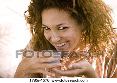 Portrait of a cheerful young woman drinking from an espresso cup View Large Photo Image Stock Image - Portrait of a cheerful young woman drinking from an espresso cup. Fotosearch