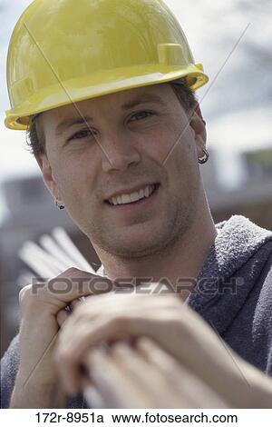 Portrait of a construction worker carrying metal pipes on his shoulder View Large Photo Image Stock Image - Portrait of a construction worker carrying metal pipes on his shoulder. Fotosearch