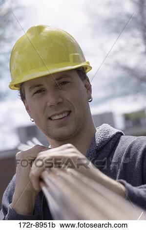 Portrait of a construction worker carrying metal pipes on his shoulder View Large Photo Image Stock Image - Portrait of a construction worker carrying metal pipes on his shoulder. Fotosearch