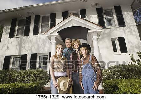 Portrait of a family in country clothes standing in front of a house View Large Photo Image Stock Photo - Portrait of a family in country clothes standing in front of a house. Fotosearch