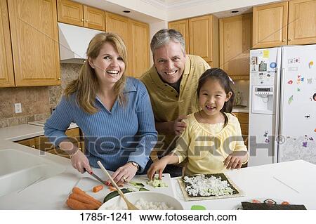 Stock Image - Portrait of a family in kitchen making sushi. Fotosearch