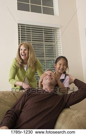 Portrait of a family playing in living room View Large Photo Image Stock Image - Portrait of a family playing in living room. Fotosearch