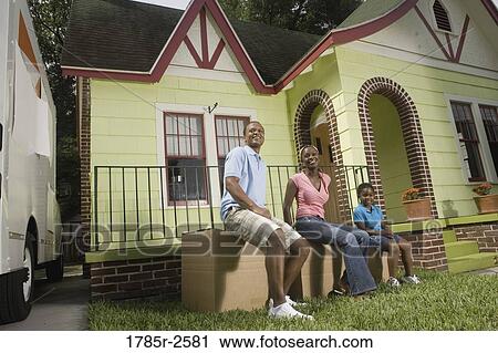 Portrait of a family sitting on boxes outside house View Large Photo Image Stock Image - Portrait of a family sitting on boxes outside house. Fotosearch