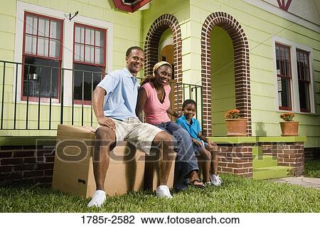 Portrait of a family sitting on boxes outside house View Large Photo Image Stock Image - Portrait of a family sitting on boxes outside house. Fotosearch
