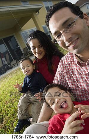 Portrait of a family sitting on lawn View Large Photo Image Picture - Portrait of a family sitting on lawn. Fotosearch