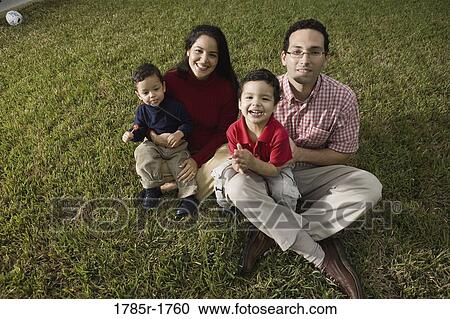 Portrait of a family sitting on lawn View Large Photo Image Stock Image - Portrait of a family sitting on lawn. Fotosearch