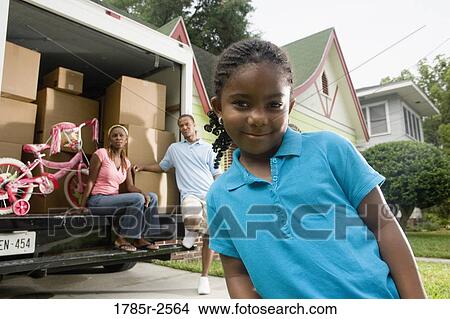 Portrait of a family standing outside a house by moving truck View Large Photo Image Picture - Portrait of a family standing outside a house by moving truck. Fotosearch