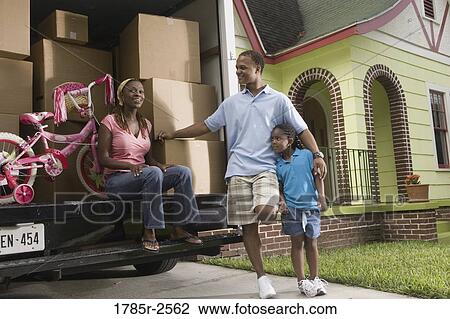 Portrait of a family standing outside a house by moving truck View Large Photo Image Stock Image - Portrait of a family standing outside a house by moving truck. Fotosearch