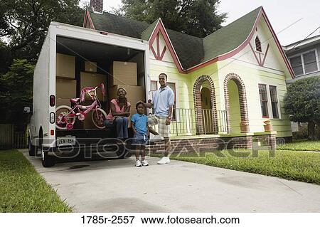 Portrait of a family standing outside a house by moving truck View Large Photo Image Stock Photo - Portrait of a family standing outside a house by moving truck. Fotosearch
