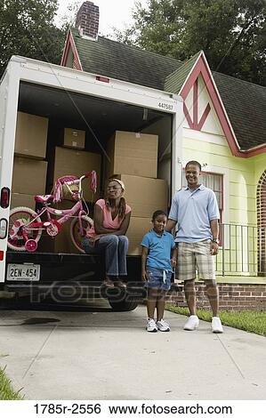 Portrait of a family standing outside a house by moving truck View Large Photo Image Stock Photograph - Portrait of a family standing outside a house by moving truck. Fotosearch